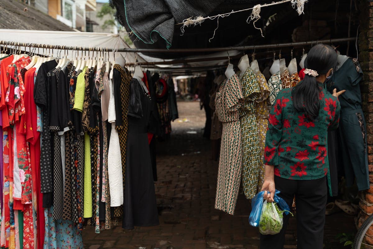 Femme présentant des vêtements sur un marché